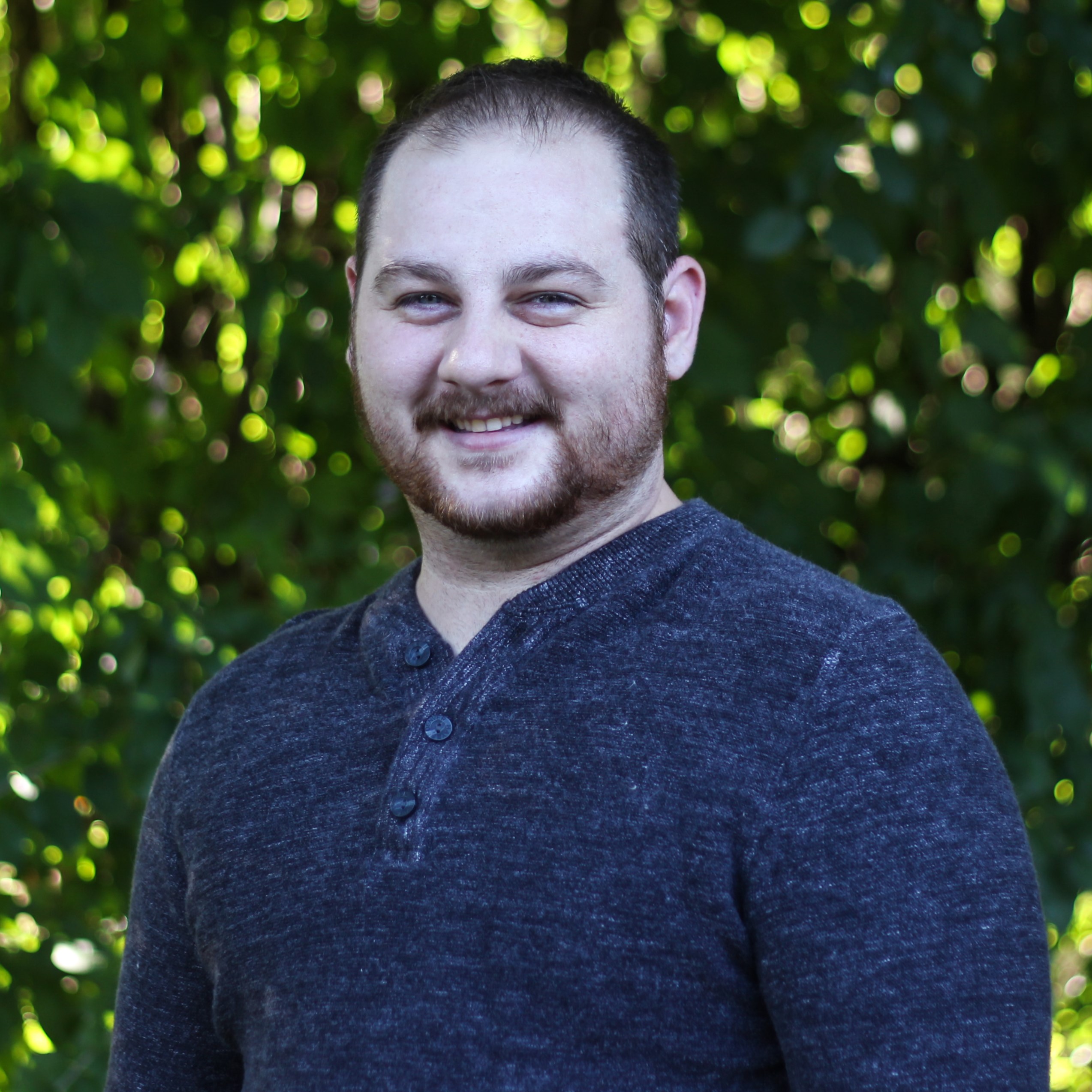 Kelsey's headshot. He is looking at the camera and smiling.